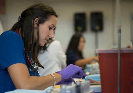 woman health worker wearing purple gloves
